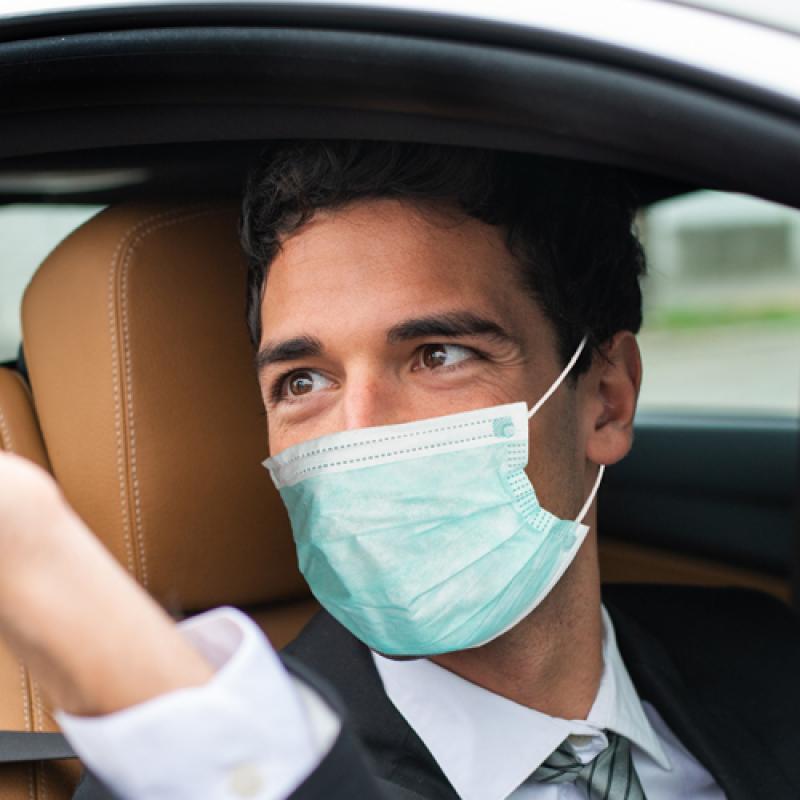 man in mask in car